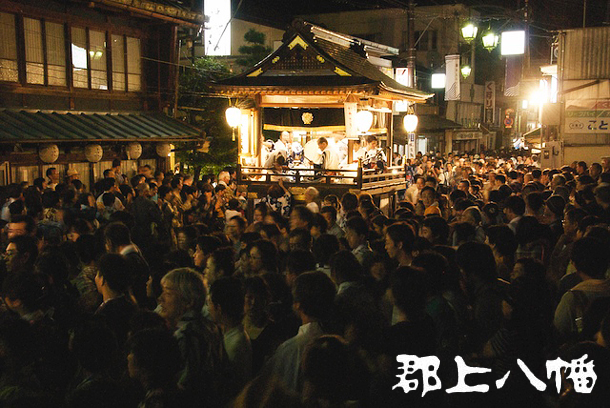 A crowd of people dancing Gujo Odori in front of the Kinenkan